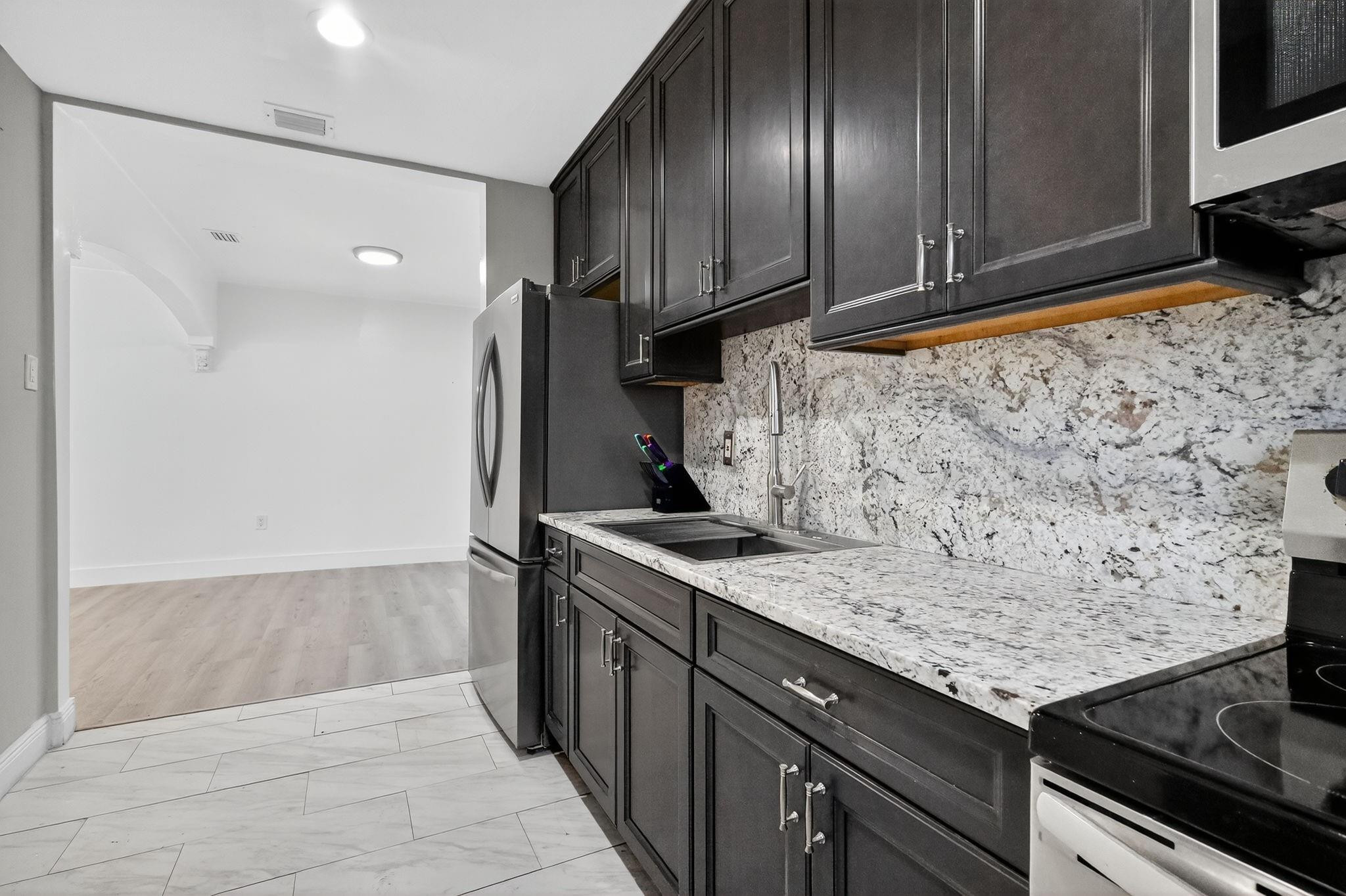 40 Northwest 68th Street Miami, FL 33150 - Photo 13 of 27 a kitchen with stainless steel appliances granite countertop wooden cabinets a refrigerator and a stove