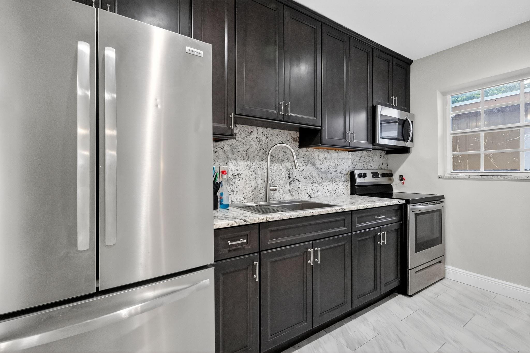 40 Northwest 68th Street Miami, FL 33150 - Photo 15 of 27 a kitchen with stainless steel appliances granite countertop a refrigerator and a sink