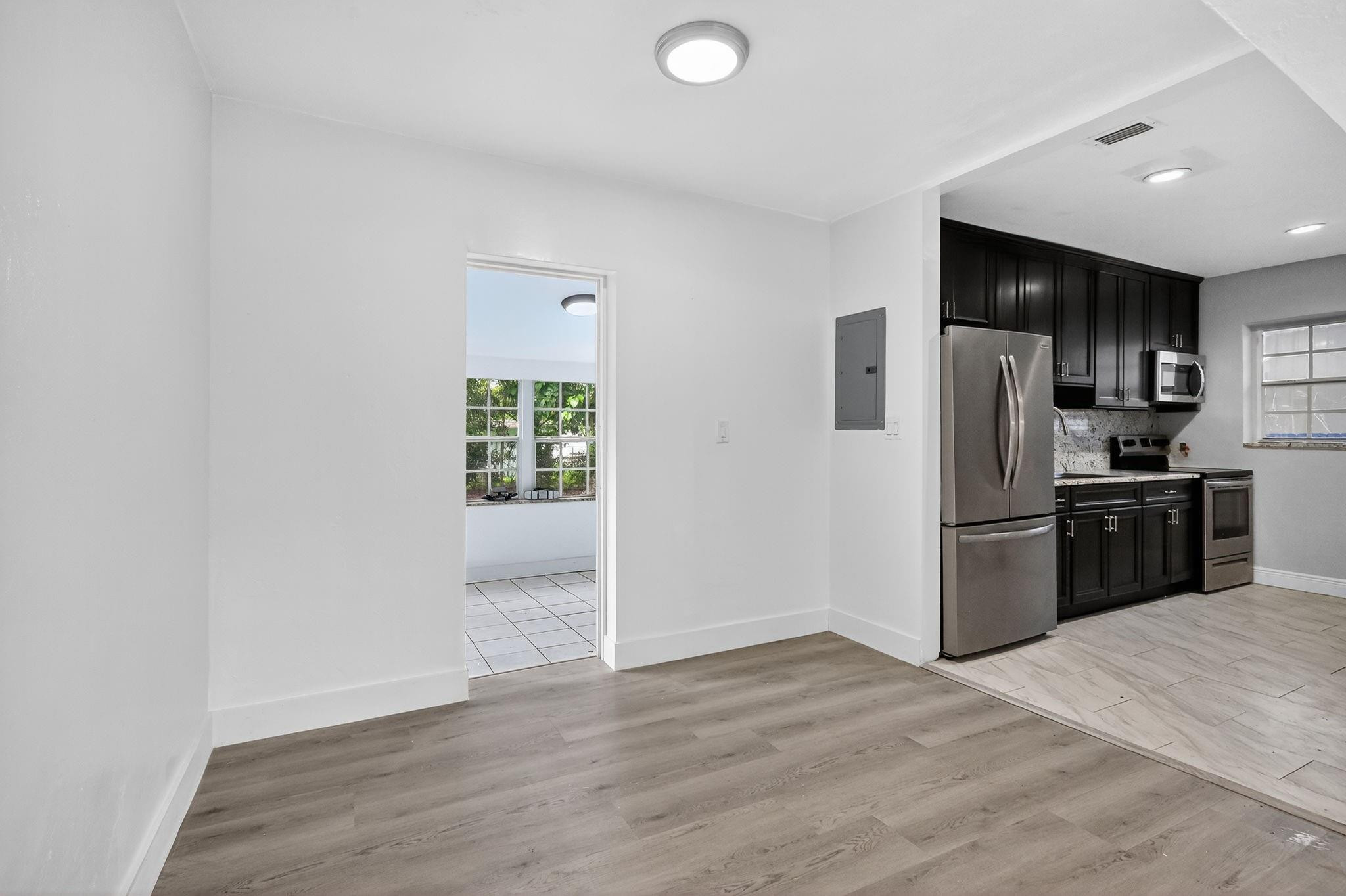 40 Northwest 68th Street Miami, FL 33150 - Photo 16 of 27 a kitchen with granite countertop a refrigerator and a stove top oven