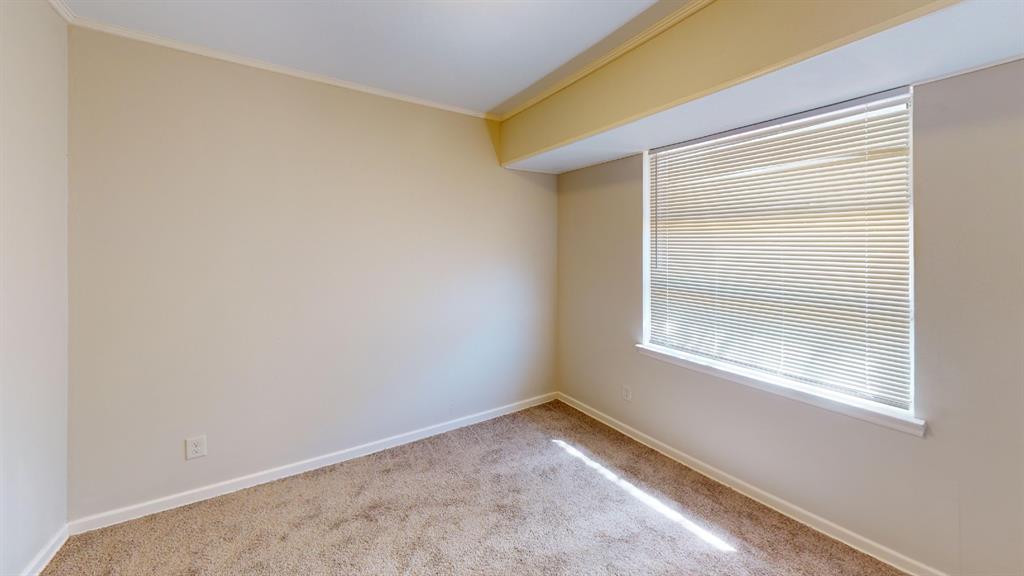 12225 Schroeder Road Dallas, TX 75243 - Photo 15 of 40 Wall-to-wall carpeting with neutral wall tones and a window with horizontal blinds
