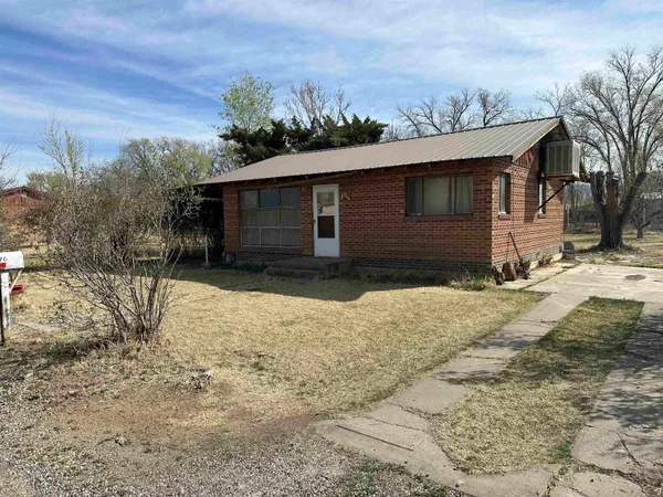 a front view of a house with a yard covered with snow