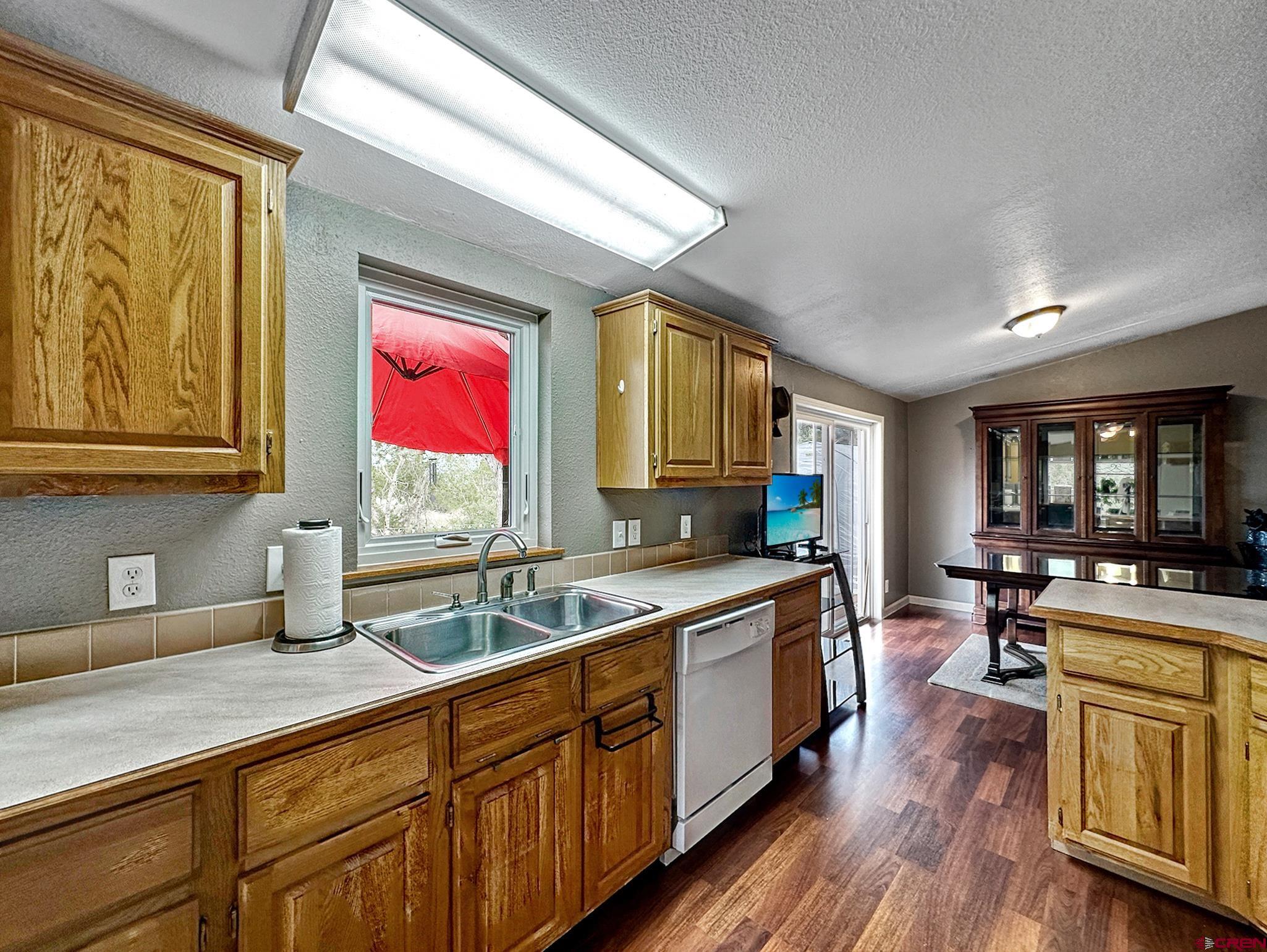 29501 P50 Road Hotchkiss, CO 81419 - Photo 13 of 45 a kitchen with stainless steel appliances granite countertop wooden floors wooden cabinets a sink a stove and a window