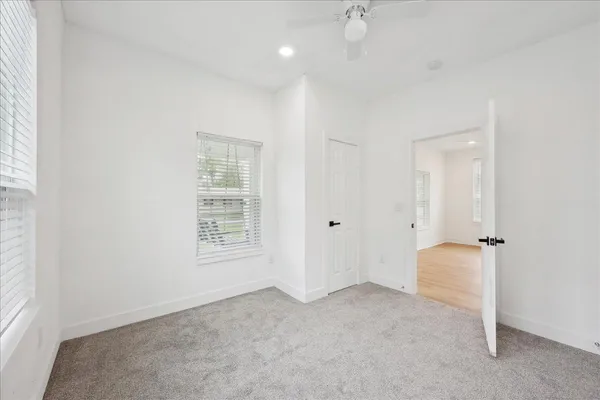 an empty room with windows and closet