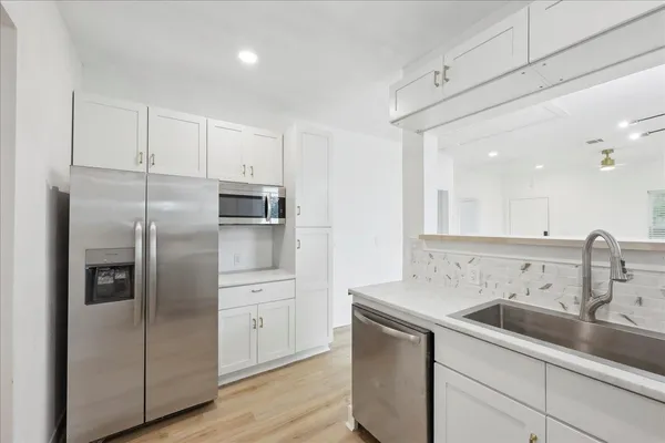a kitchen with a sink stainless steel appliances and cabinets