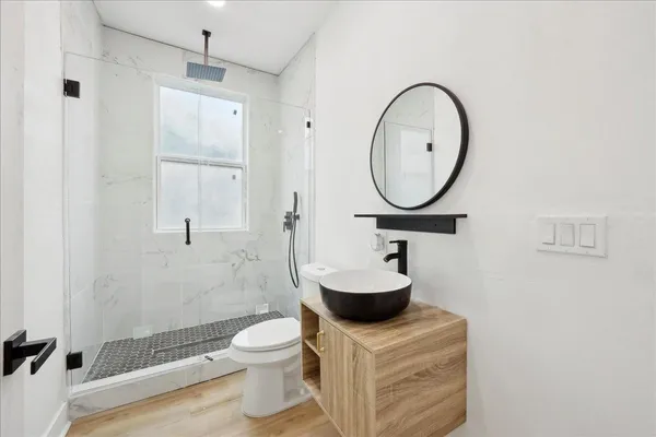 a bathroom with a sink a toilet and a mirror