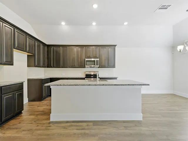 a view of kitchen with stainless steel appliances granite countertop wooden cabinets and a granite counter tops