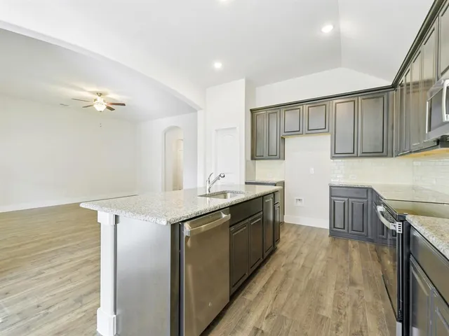 a kitchen with stainless steel appliances granite countertop a sink stove and refrigerator