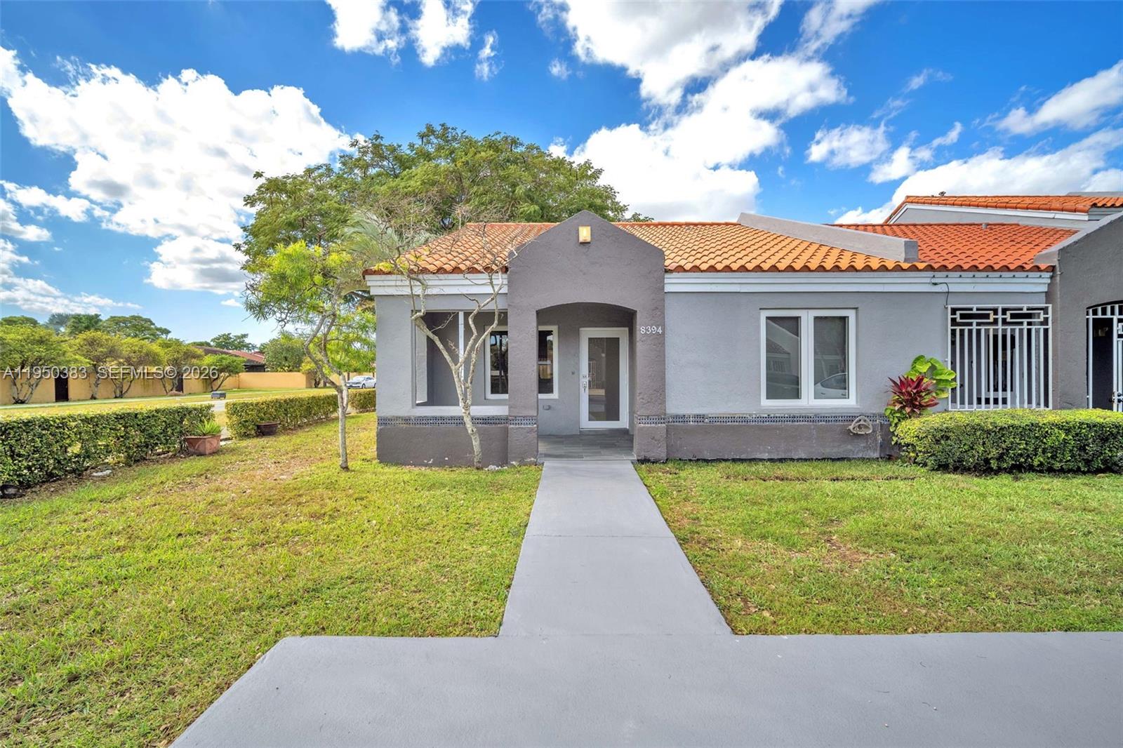 8394 Southwest 148th Avenue, Unit 8394 Miami, FL 33193 - Photo 2 of 15 a front view of a house with garden