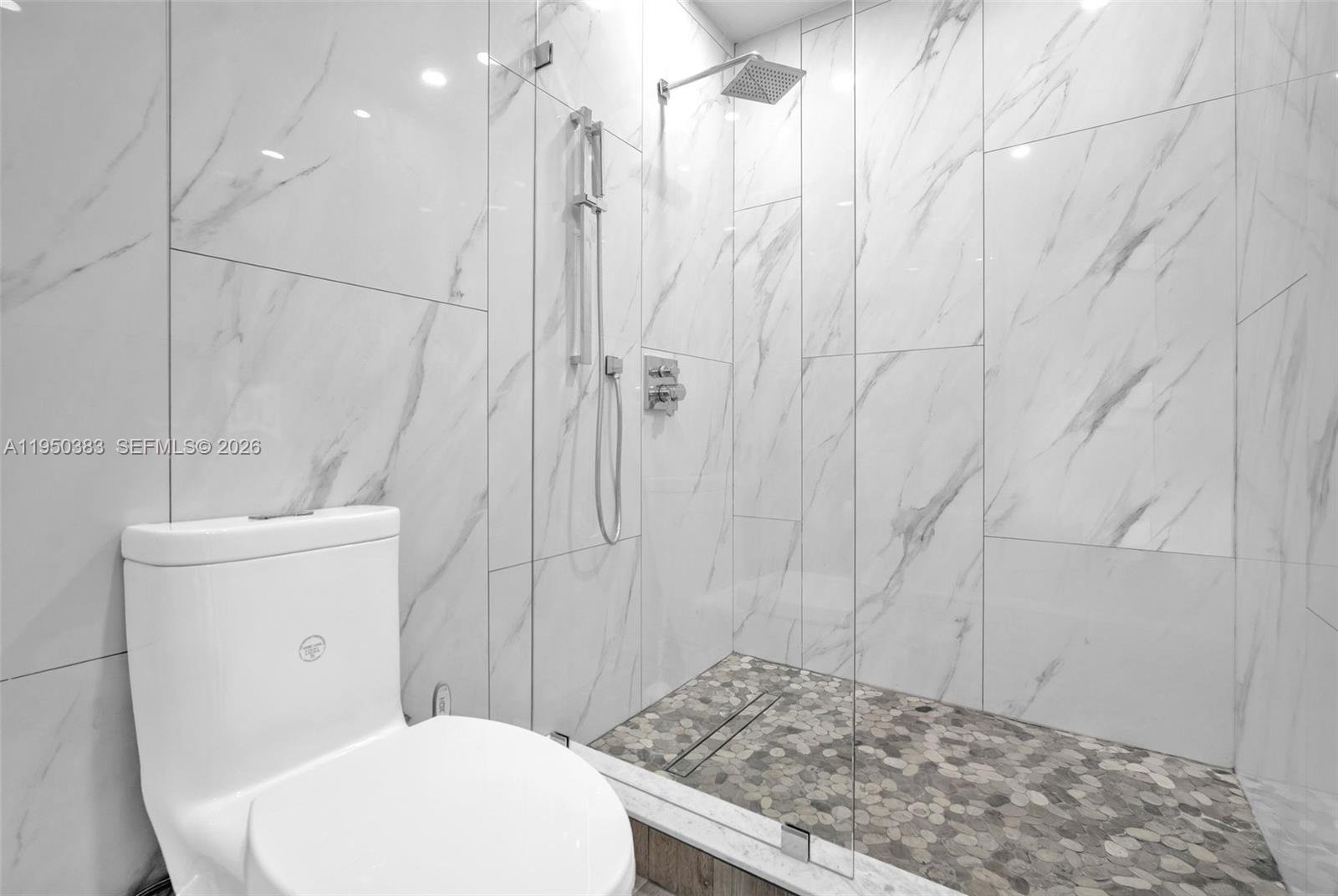 8394 Southwest 148th Avenue, Unit 8394 Miami, FL 33193 - Photo 9 of 15 a bathroom with a granite countertop sink a toilet and shower