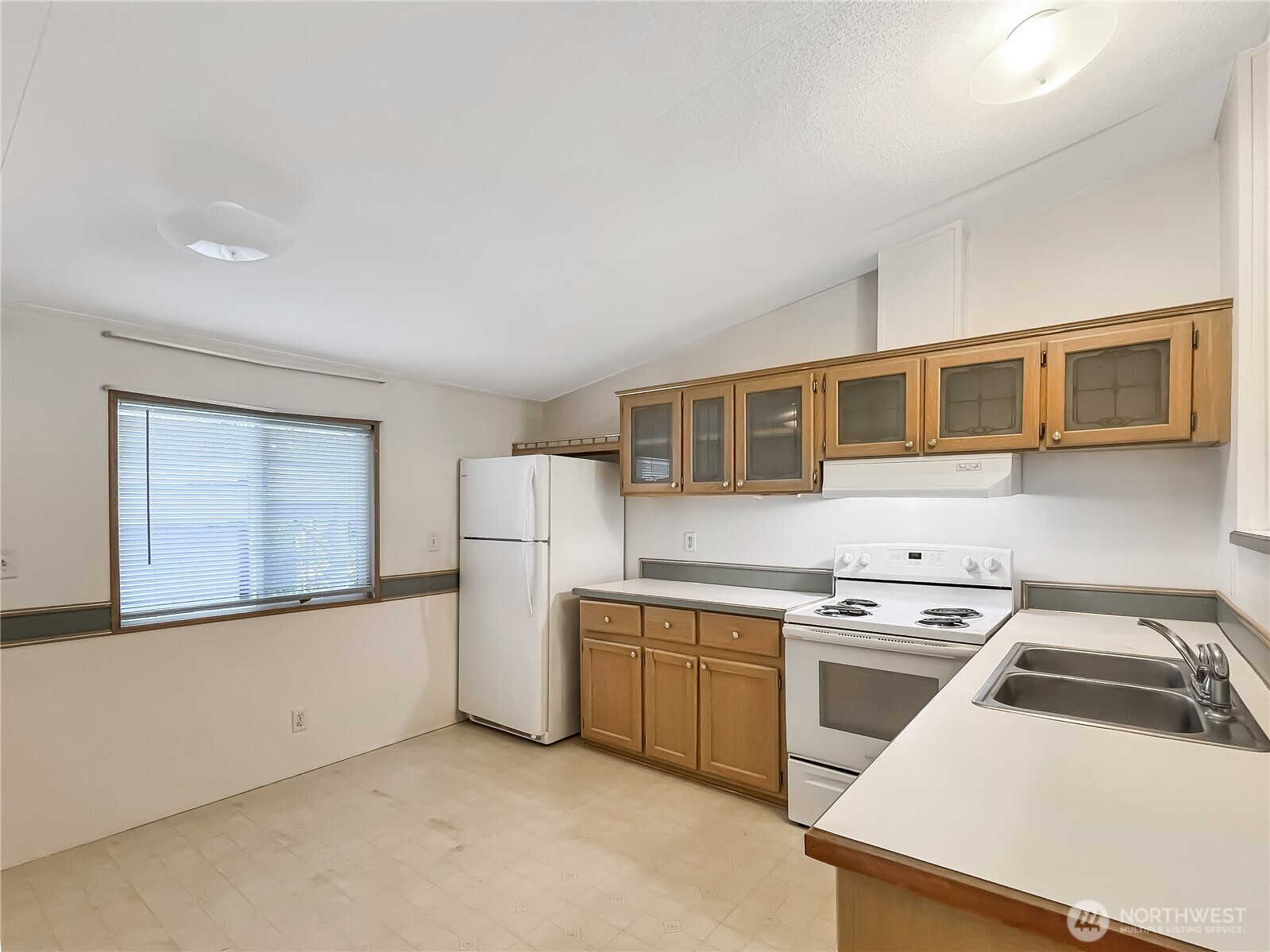 10900 Kuhlman Road Southeast, Unit 54 Olympia, WA 98513 - Photo 5 of 15 a kitchen with a stove a sink and a refrigerator
