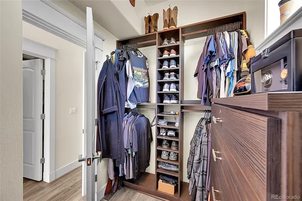 a view of walk in closet with clothes and shoes