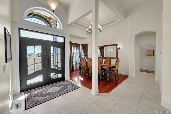 a living room with furniture a large window and a chandelier