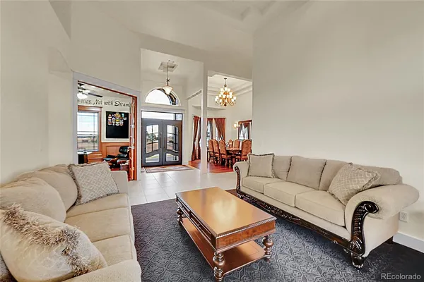 a living room with fireplace furniture and a view of kitchen