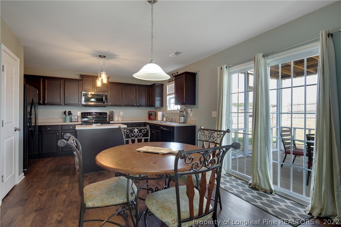 445 Botanical Court Bunnlevel, NC 28323 - Photo 14 of 38 a kitchen with a dining table chairs and refrigerator