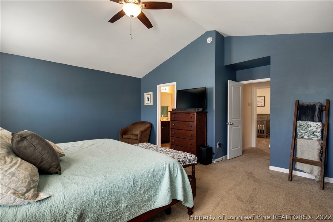 445 Botanical Court Bunnlevel, NC 28323 - Photo 16 of 38 a bedroom with a bed and a chandelier