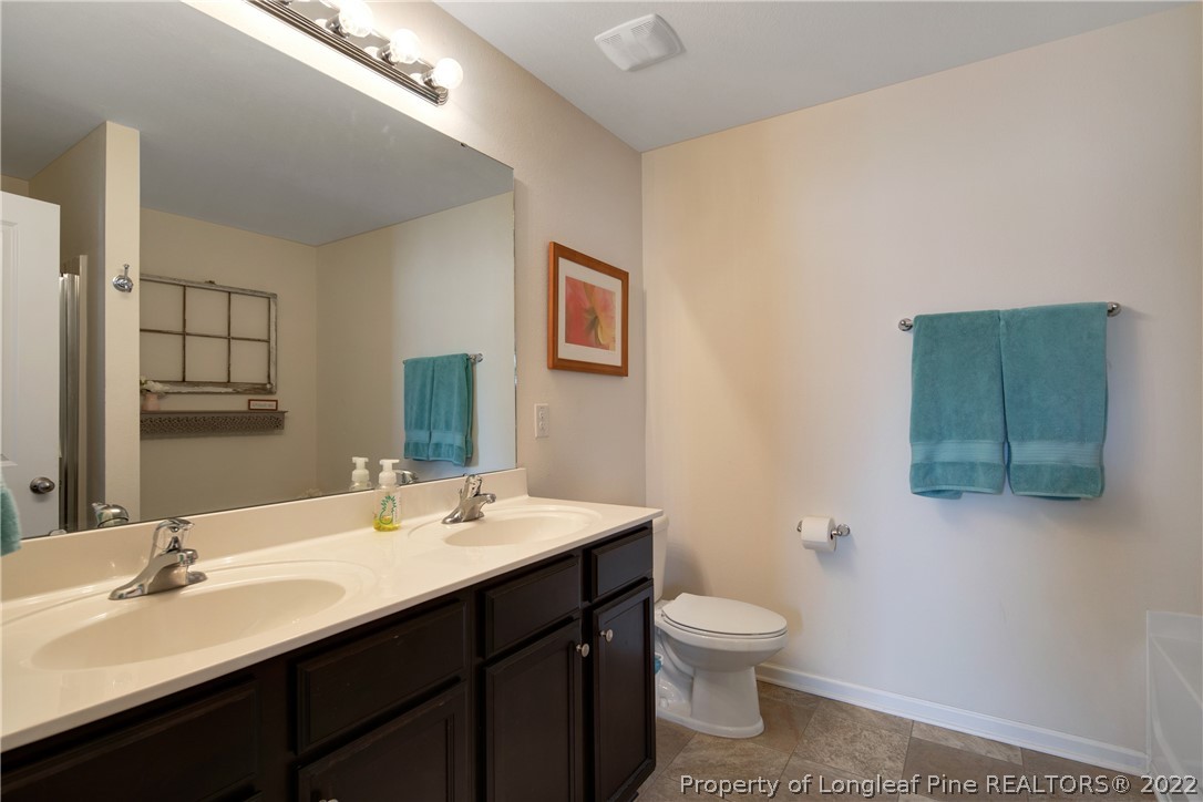 445 Botanical Court Bunnlevel, NC 28323 - Photo 17 of 38 a bathroom with a toilet sink and mirror