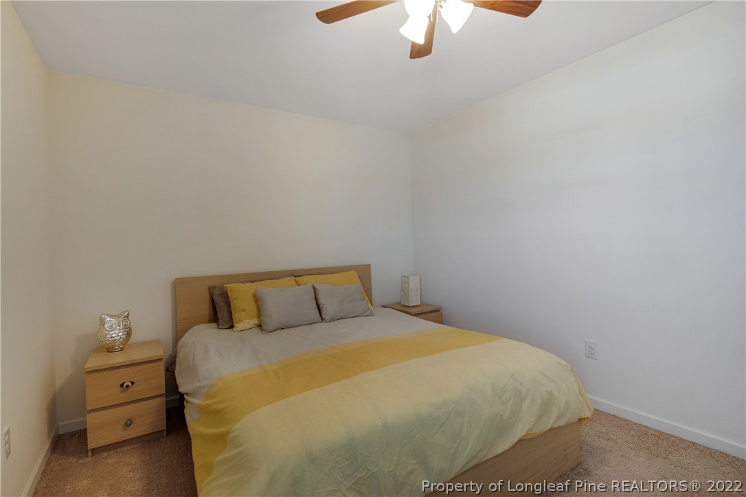 445 Botanical Court Bunnlevel, NC 28323 - Photo 24 of 38 a bedroom with a bed and a chandelier fan