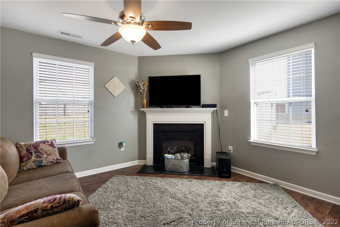 445 Botanical Court Bunnlevel, NC 28323 - Photo 9 of 38 a living room with furniture a flat screen tv and a fireplace