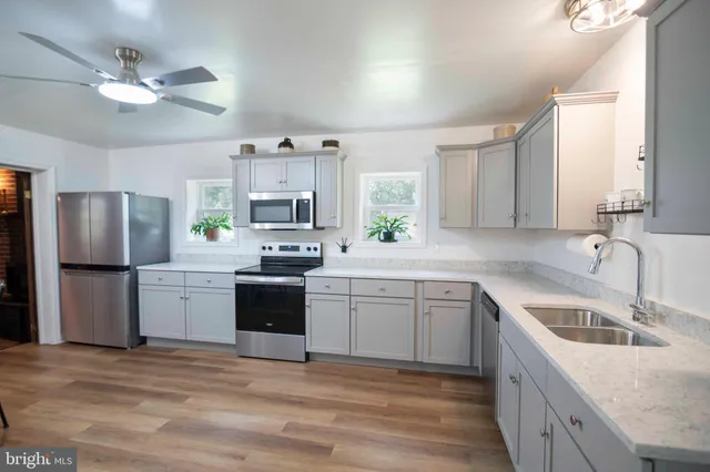 a kitchen with a sink stove a refrigerator and white cabinets