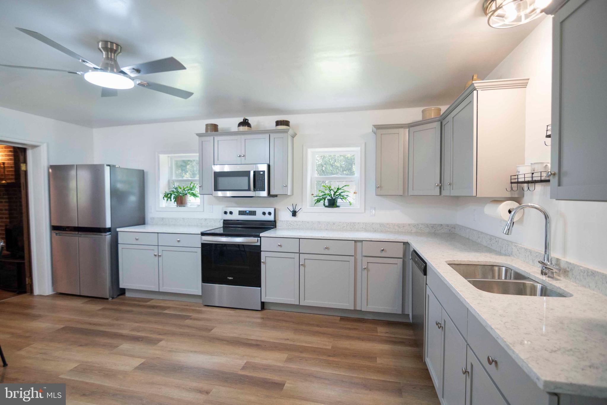 2002 Balkamore Hill Road Stanley, VA 22851 - Photo 19 of 45 a kitchen with a sink stove a refrigerator and white cabinets