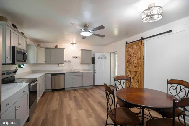 a kitchen with a table chairs microwave and cabinets