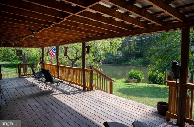 a view of a deck with wooden floor and roof with a floor to ceiling window with wooden floor
