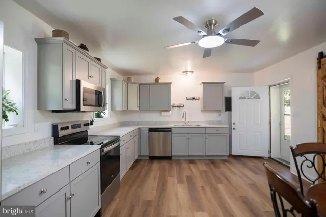 a kitchen with a sink a counter space appliances and cabinets
