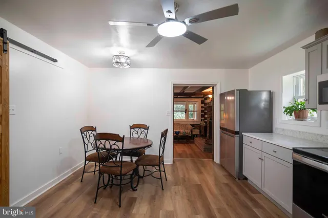 a view of a dining room with furniture and a chandelier fan