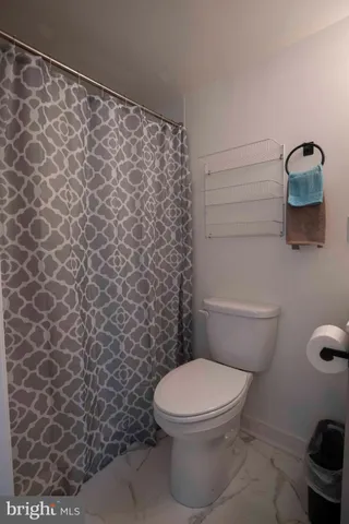 a white toilet sitting next to a shower curtain