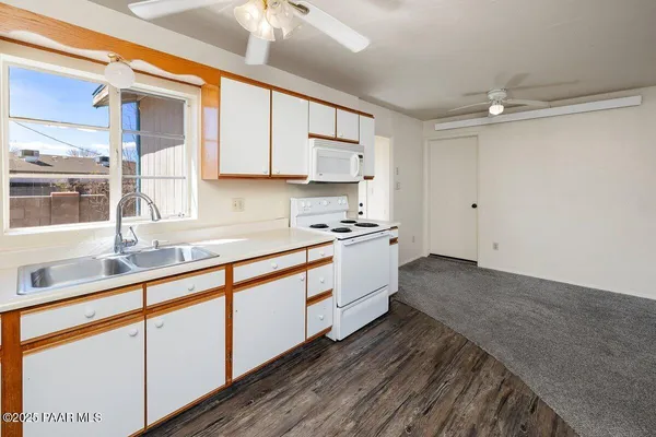 a kitchen with granite countertop white cabinets and white appliances
