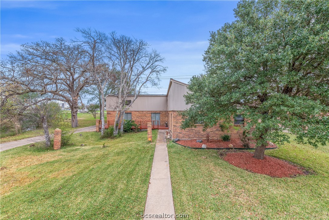 a front view of a house with a yard and trees