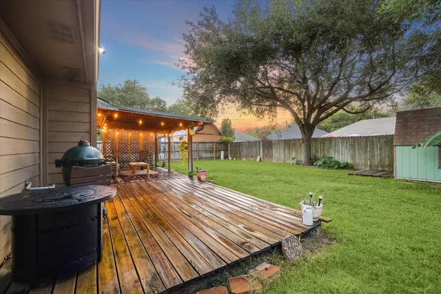 a view of a porch with a table and chairs under an umbrella