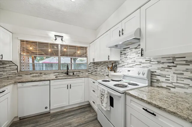 a kitchen with stainless steel appliances granite countertop a stove sink and cabinets