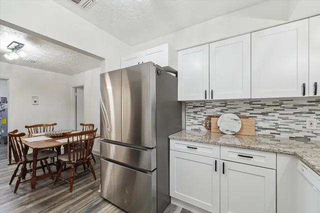 a kitchen with stainless steel appliances granite countertop a refrigerator and a stove top oven