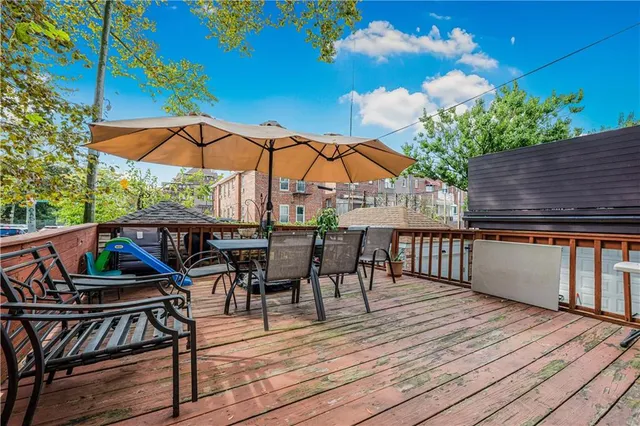 a view of a roof deck with table and chairs under an umbrella
