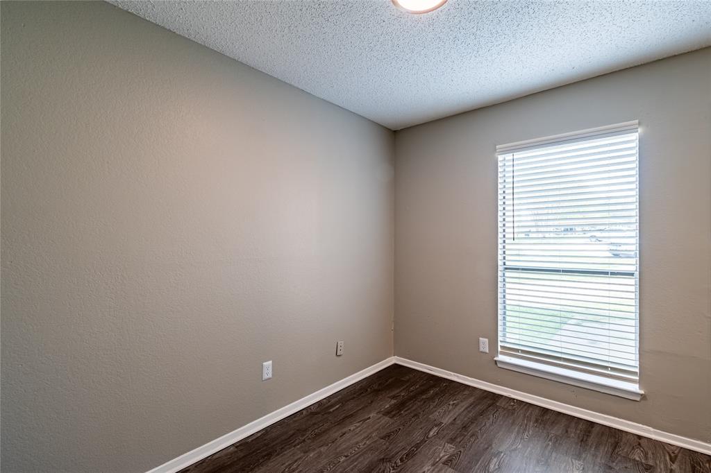 806 Treadwell Court, Unit B Hurst, TX 76053 - Photo 11 of 27 wooden floor in an empty room with a window