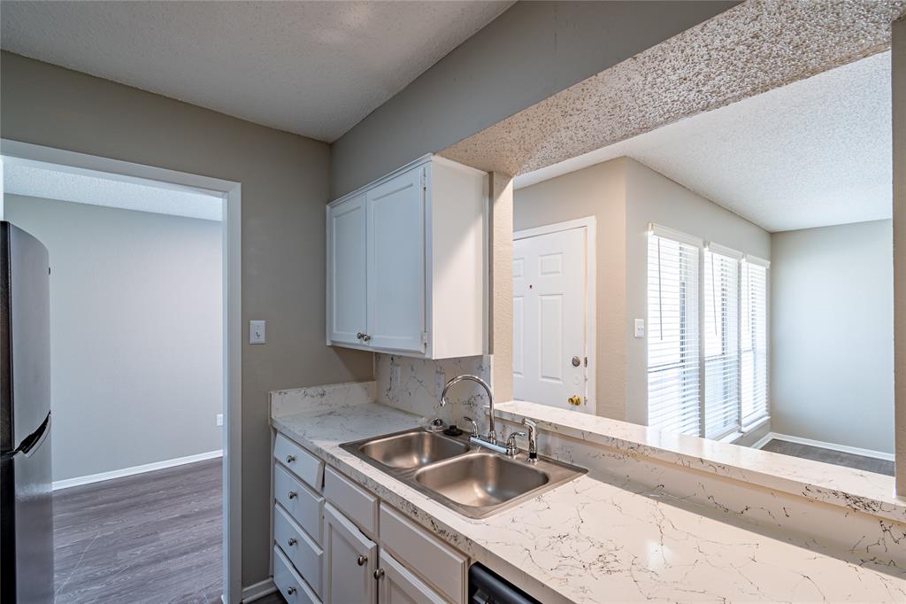806 Treadwell Court, Unit B Hurst, TX 76053 - Photo 14 of 27 a kitchen with a sink and cabinets