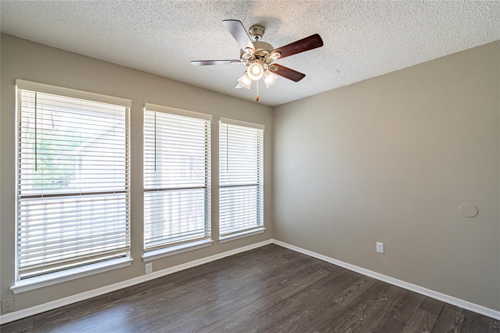 806 Treadwell Court, Unit B Hurst, TX 76053 - Photo 16 of 27 a view of an empty room with wooden floor and a window