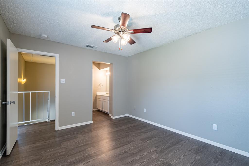 806 Treadwell Court, Unit B Hurst, TX 76053 - Photo 22 of 27 an empty room with wooden floor fan and windows