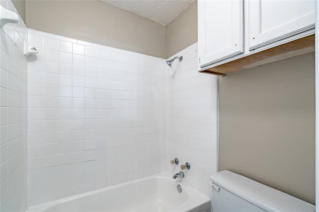 806 Treadwell Court, Unit B Hurst, TX 76053 - Photo 26 of 27 a bathroom with a bathtub and shower