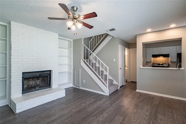 a living room with wooden floor and a fireplace