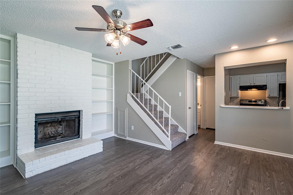 806 Treadwell Court, Unit B Hurst, TX 76053 - Photo 5 of 27 a living room with wooden floor and a fireplace