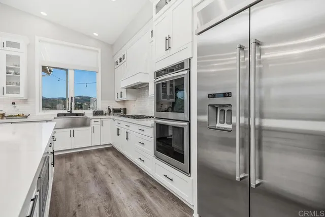 a kitchen with stainless steel appliances a refrigerator sink and microwave