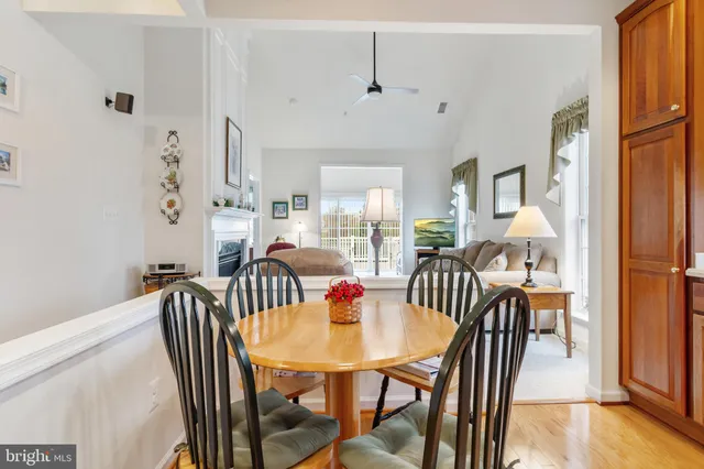 a view of a dining room and livingroom with furniture wooden floor a chandelier