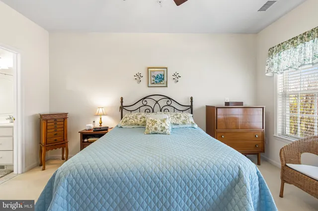 a bedroom with a bed and a large mirror with window