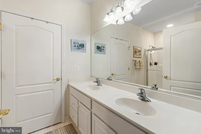 a bathroom with a double vanity sink a mirror and a shower