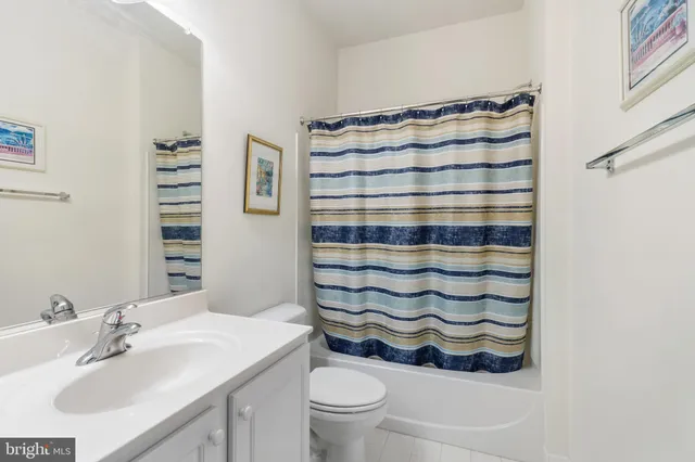 a bathroom with a sink a toilet and shower curtain