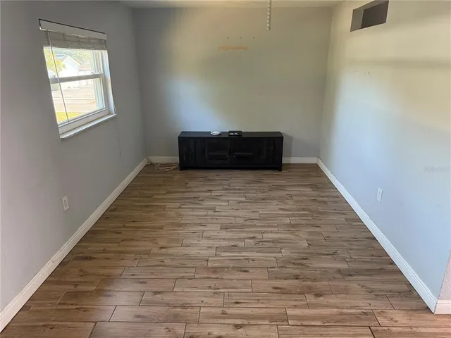 a room with wooden floor and window