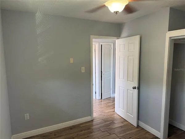 a view of a room with wooden floor and a ceiling fan