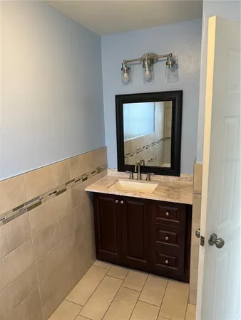 a bathroom with a granite countertop sink and a mirror